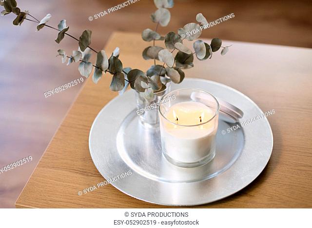 burning white candles on table at cozy home