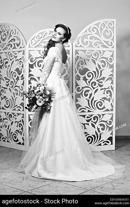 beautiful dark hair young woman in champagne color wedding gown. bride with fashion hairstyle. studio shot