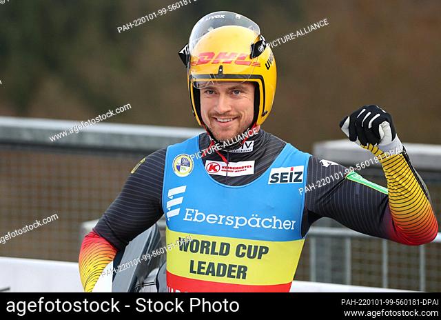 dpatop - 01 January 2022, North Rhine-Westphalia, Winterberg: Luge: World Cup, men's single, 2nd heat: Johannes Ludwig of Germany raises his fist after the...