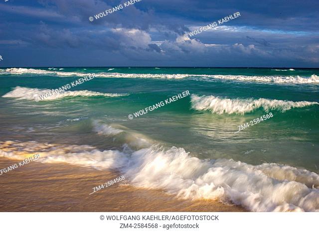 Waves crashing on a white sand beach during a storm along the east coast of the Yucatán Peninsula on the Caribbean Sea at Playa del Carmen on the Riviera Maya...