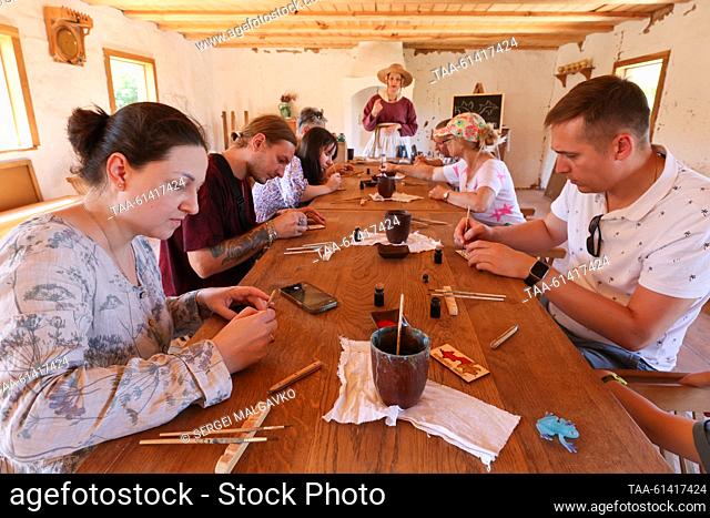 RUSSIA, SEVASTOPOL - AUGUST 27, 2023: People attend a painting master class as part of the City of Craftsmen Medieval Crafts show at the Genoese manor of the...