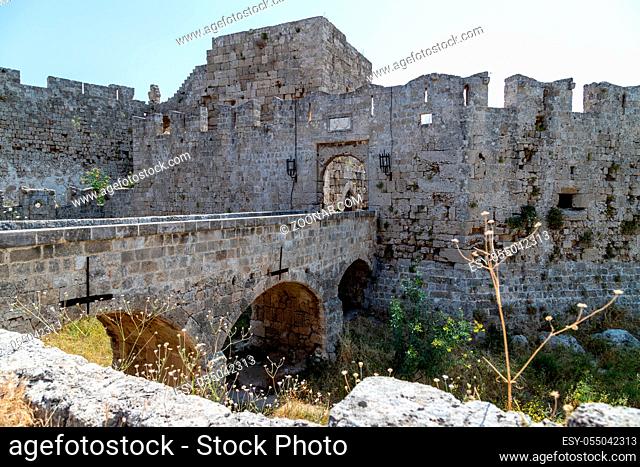 Part of the historic city wall of Rhodes town with bridge and entrance gate on Rhodes island, Greece on a sunny day