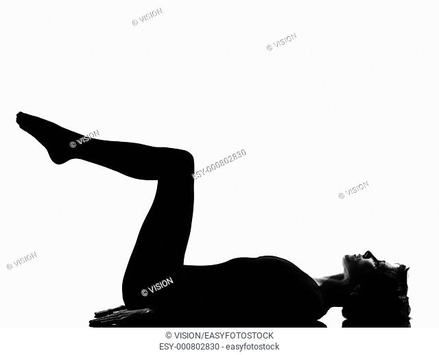 woman exercising lying on back fitness yoga stretching in shadow grayscale silhouette full length in studio isolated white background