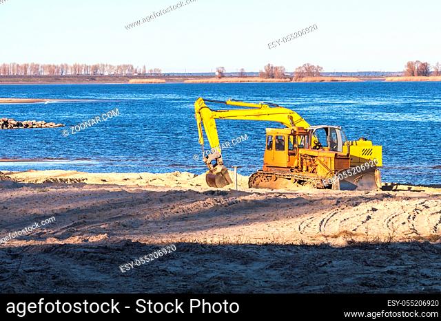Excavator or digger and excavators working on ground. Industrial machinery at working construction building site near river