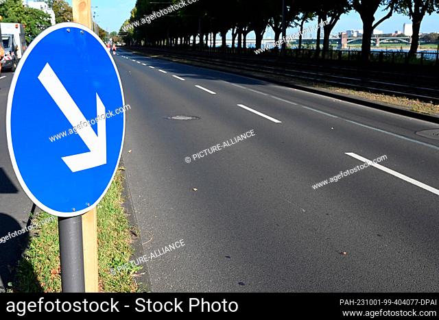 01 October 2023, North Rhine-Westphalia, Cologne: Traffic sign arrow, traffic direction sign white arrow on blue background indicates the direction of travel