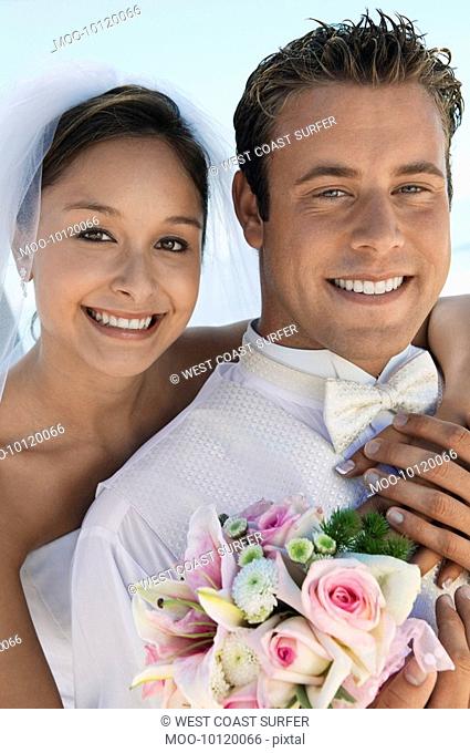 Bride and Groom with bouquet outdoors close-up portrait