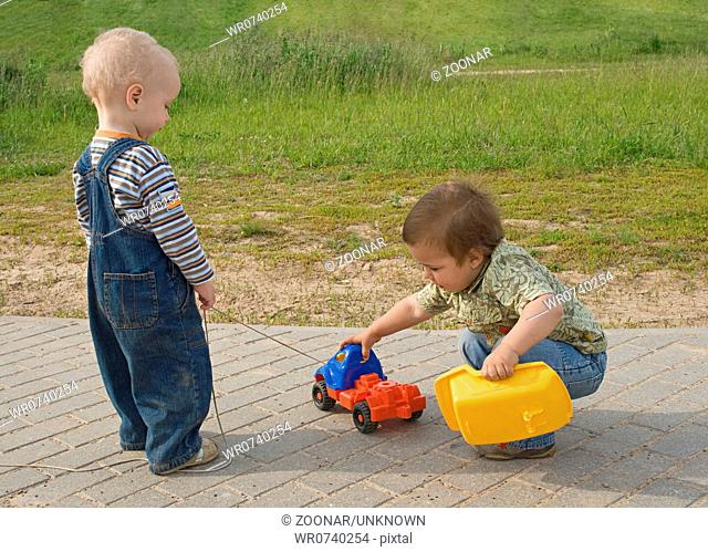 Two boys trying to repair a toy truck