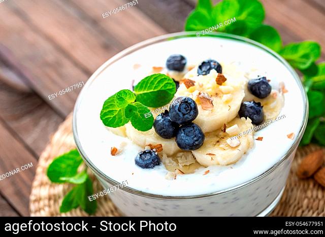 Yogurt with fresh blueberry, banana and almond nuts, delicious dessert for healthy breakfast