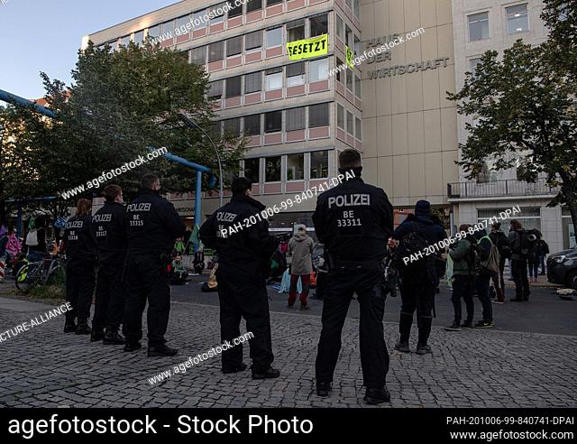 06 October 2020, Berlin: Police officers are standing outside the Haus der Wirtschaft in Charlottenburg, where environmental activists from Extinction Rebellion...