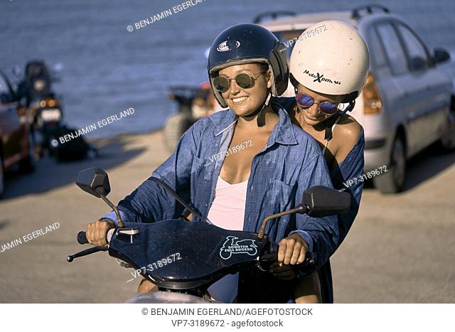 Two women driving scooter, Chersonissos, Crete, Greece