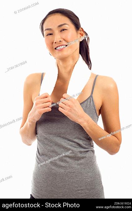 Smiling fitness Asian woman with towel around her neck posing isolated over white background