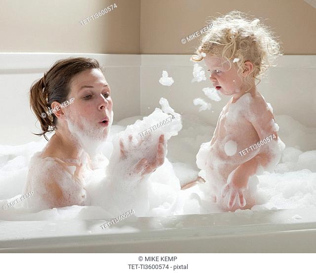 Mother and child having bubble bath