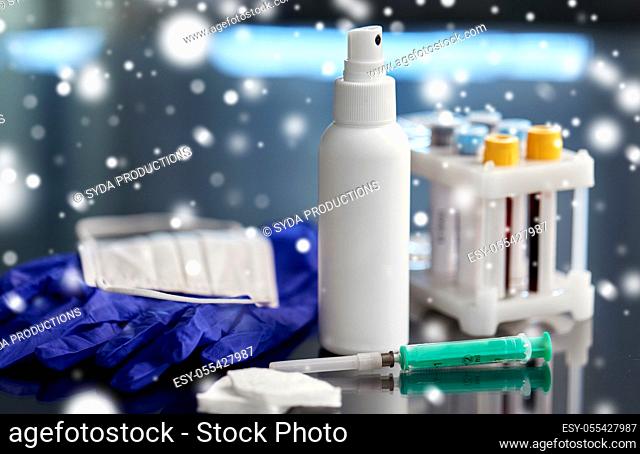syringe, beakers with blood test, gloves and mask