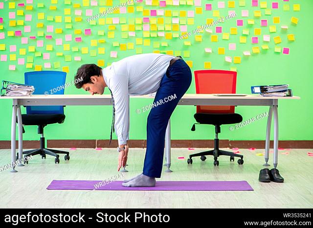 Man in the office with many conflicting priorities doing exercises