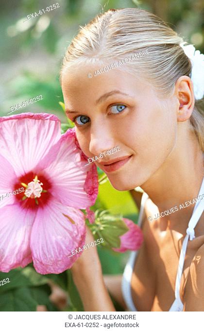 Woman holding large flower outdoors