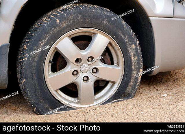 VILNIUS, LITHUANIA - MARCH 03, 2016: The punched lowered wheel of the American car Dodge on rural sandy Lithuanian roads