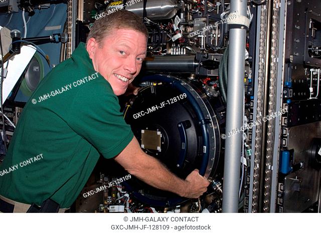 NASA astronaut Mike Fossum, Expedition 28 flight engineer, is pictured at the Combustion Integrated Rack (CIR) Multi-user Drop Combustion Apparatus (MDCA) in...