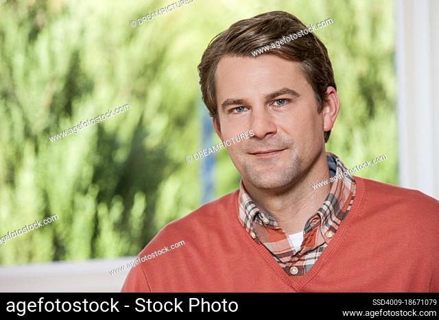 Portrait of a Caucasian man dressed in business casual clothing looking into camera with calm smile