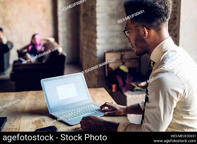 Creative businessman using laptop in loft office