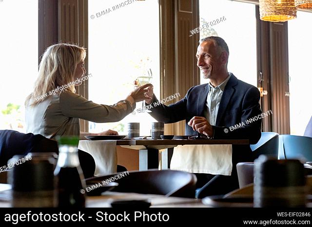 Couple toasting champagne glasses at lunch date in restaurant