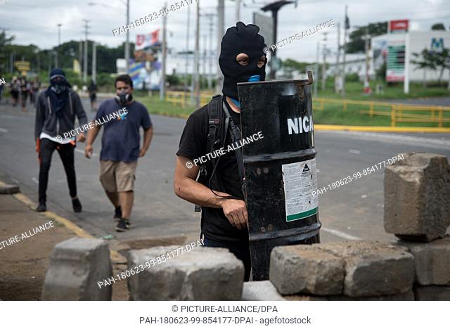 23 June 2018, Nicaragua, Managua: Hooded students stand in the university with a self-made shield. Paramilitaries stormed the National Autonomous Universities...