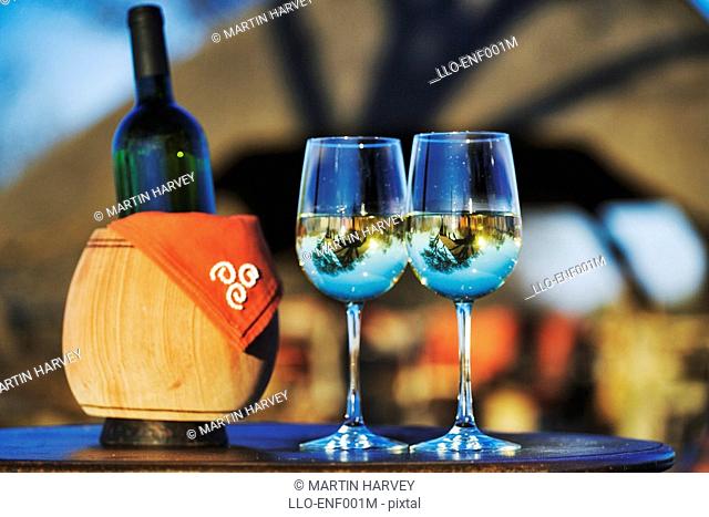 Romantic Scene with Two White Wine Glasses and a Ice Bucket with the Reflection of a Lapa in Glasses  Okonjima Private Game Reserve, Namibia, Southern Africa
