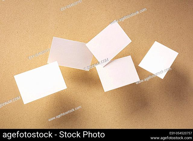 White thick business cards, flying on a brown paper background, a mock-up for a creative design presentation