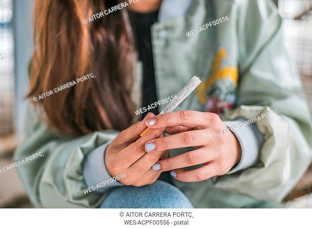 Woman's hands rolling a Marihuana joint, close-up
