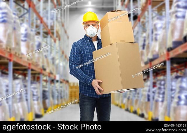 worker in respirator mask with boxes at warehouse