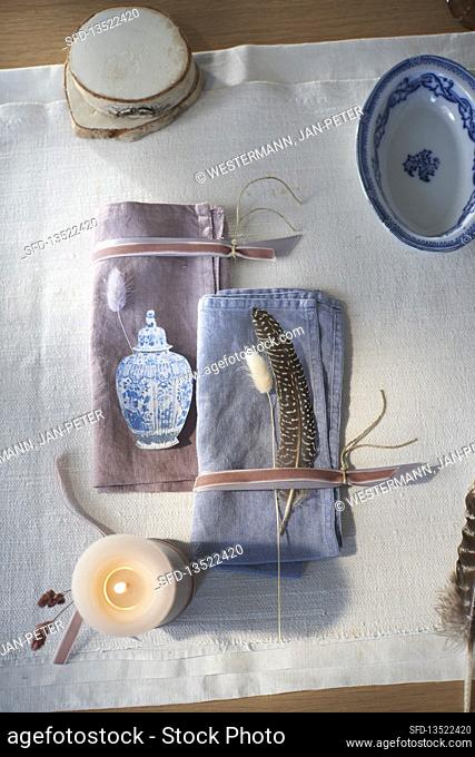 Cloth napkins with velvet ribbon, grasses and feathers