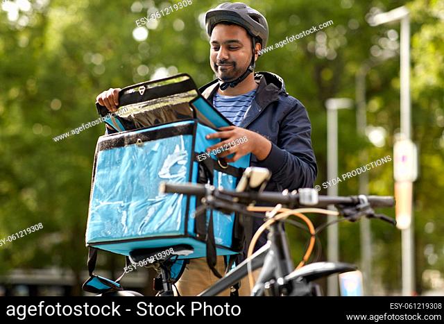 food delivery man with bag and bicycle in city