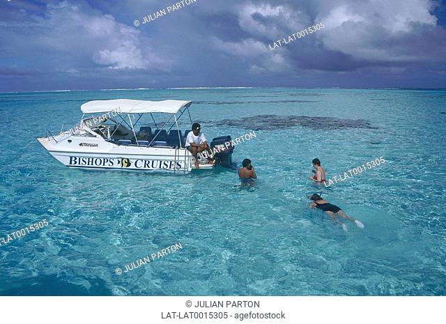 People snorkelling off boat in lagoon. Melanesia. South Pacific