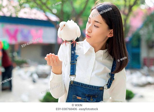 smiling girl with pigeons on the arm, asian woman