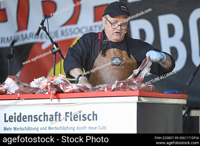 07 August 2022, Hessen, Fulda: Meat is prepared at a booth of the 25th German Grill and BBQ Championship. The championship took place in Fulda from August 6 to...