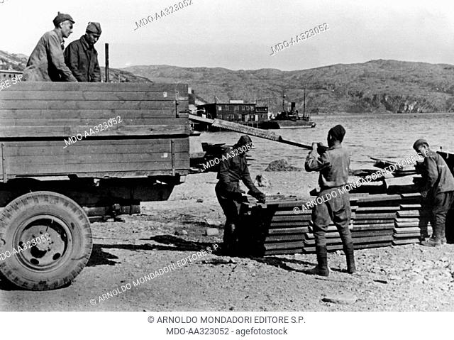 Unloading wood from a truck. Some Russian prisoners unloading wood from a truck in the Lake Ladoga area. Russia, September 1941