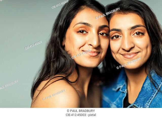 Portrait smiling, confident teenage twin sisters
