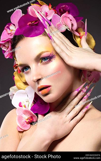Beautiful woman with long nails, perfect skin, hair of orchids. Portrait shot in the studio