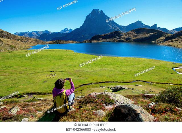 a woman hiker take a picture from the Pic Ossau, France