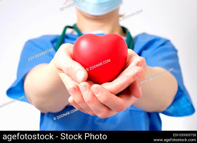 Female doctor holding a red heart shape