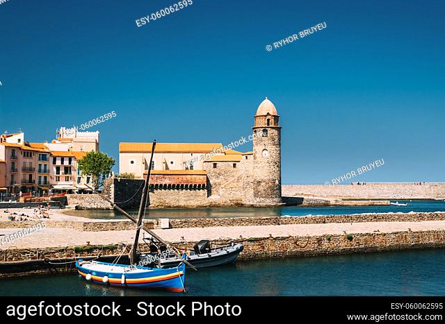 Collioure, France. Boats Moored On Berth Near The Church Of Our Lady Of The Angels Across Bay In Sunny Spring Day