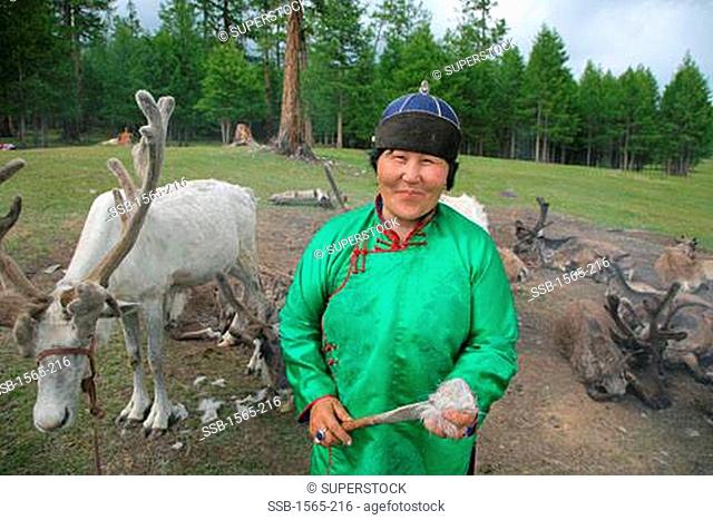 Tsaatan woman standing reindeers, Lake Khovsgol, Sayan Mountains, Khovsgol Nuur, Lake Khovsgol National Park, Mongolia
