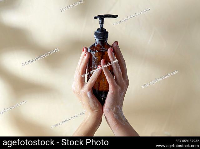 hands with bottle of shower gel or liquid soap