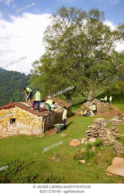 Group of young people working in the reconstruction of an old country house, Aizkorri Natural Park, Gipuzkoa, Euskadi, Spain