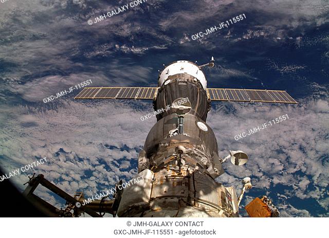 A blanket of clouds provides the backdrop for this scene of the Soyuz TMA-6 spacecraft, docked to the Pirs Docking Compartment on the International Space...