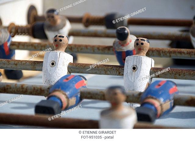 An old foosball table with wooden players, close-up