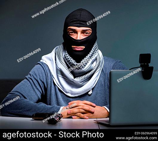 The hacker wearing balaclava mask hacking computer
