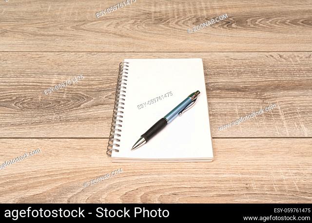 an empty block and a pen on the wooden table