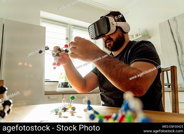Man with VR Goggles examining molecular model at home