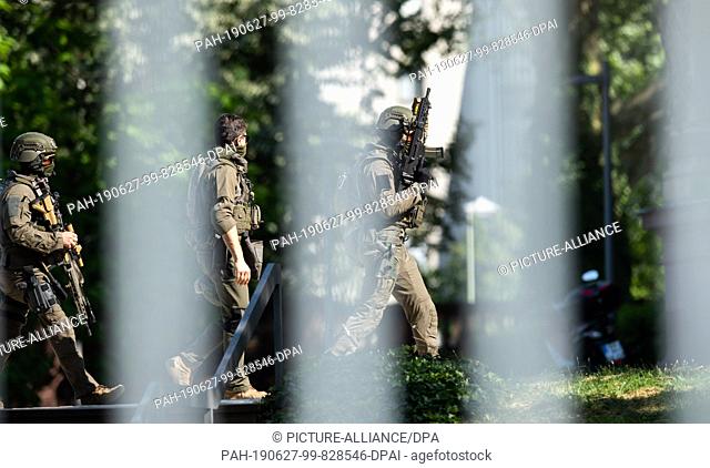 27 June 2019, Baden-Wuerttemberg, Karlsruhe: Armed policemen enter the grounds of the Federal Court of Justice. In the Lübcke murder case