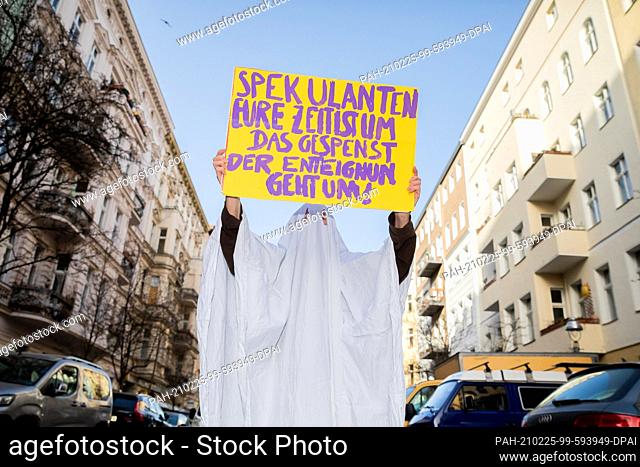 25 February 2021, Berlin: An activist in a ghost costume holds a protest sign near the organizing office of the people's petition ""Expropriate Deutsche Wohnen...